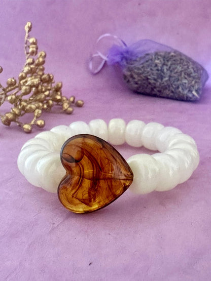 Bracelet élastique CLAUDIE de perles colorées cylindriques et coeur - Camilmari Bijoux - Écru marbré avec un cœur marron ambré